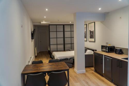 a room with a table and chairs and a bed at La Borda del Gato Rafa in Vielha