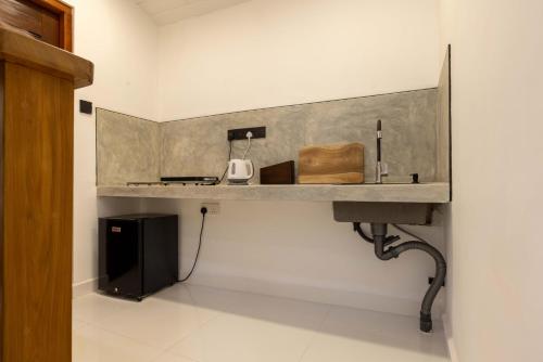 アハンガマにあるMellow Yellow Ahangamaのシンクと電子レンジ付きのキッチンカウンター