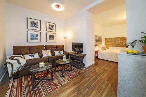 a living room filled with furniture and a bed at Apartamentos Los Venerables in Seville