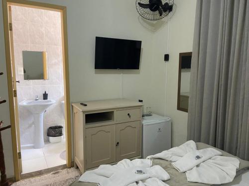 uma casa de banho com uma cama, um lavatório e uma televisão em Vila Marias em Ouro Preto