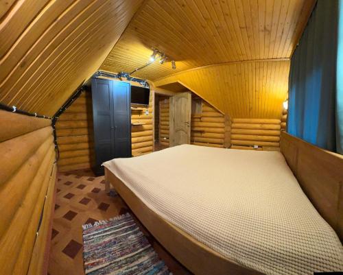 a bedroom with a bed in a wooden room at Pid skeleju in Rakhiv