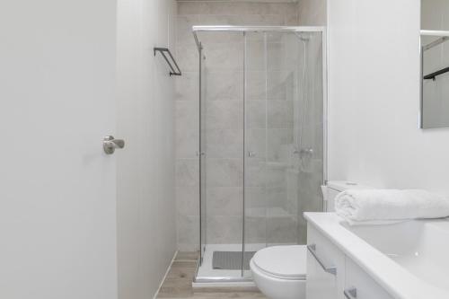 a white bathroom with a shower and a toilet at Apartamento Ajm in Barbate