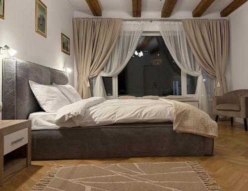 Un dormitorio con una cama con sábanas blancas y una ventana. en The Bucket - Calla Old Town with Jacuzzi, en Brasov