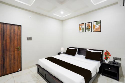a bedroom with a large bed and a wooden door at Super Townhouse Rajendra Nagar Main Road in Indore