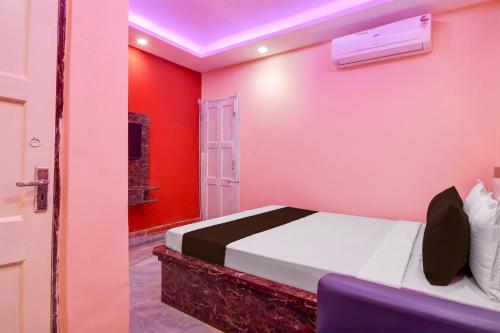a bedroom with red and white walls and a bed at Hotel O Prasad Inn in Ballygunge