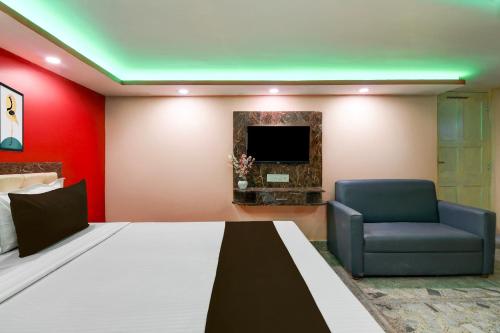 a room with a bed and a chair and a tv at Hotel O Prasad Inn in Ballygunge