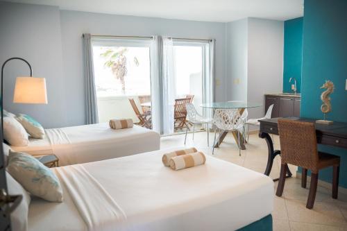 een hotelkamer met 2 bedden, een bureau en een tafel bij HOTEL CARASOL VILLAS & SUITES in Ciudad Madero