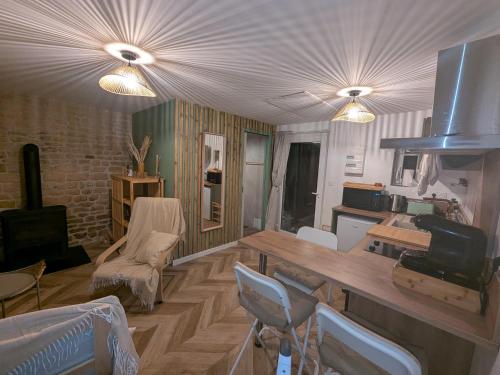 Una sala de estar con una mesa y sillas de madera. en Jo And Manu's Barn, en Falaise