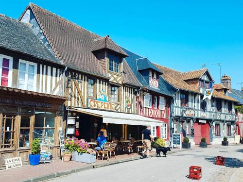 Un grupo de edificios en una calle con gente y perros. en Jo And Manu's Barn, en Falaise