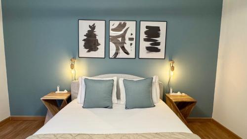 a bedroom with a bed with four pictures on the wall at WHome Charming & Stylish Apartment in Benfica in Lisbon