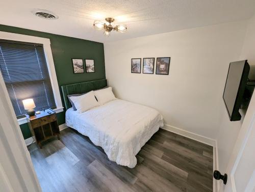 una camera da letto con un letto e una parete verde di Downtown 3 Bed Loft Apartment a Delaware