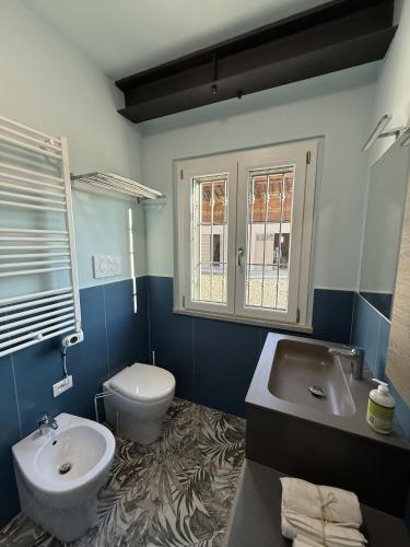 a blue bathroom with a toilet and a sink at NessunConfine Casa Sara in Santa Giuletta