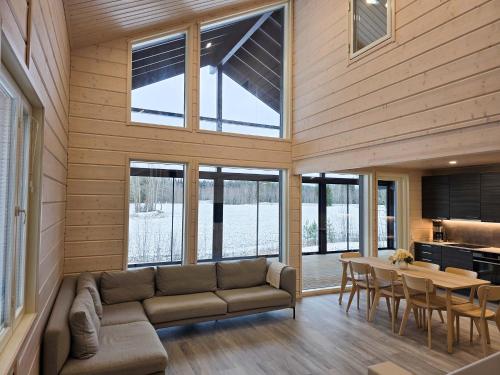 ein Wohnzimmer mit Sofa und Tisch in der Unterkunft Villa Taipale - 8hlö, Himosranta in Jämsä