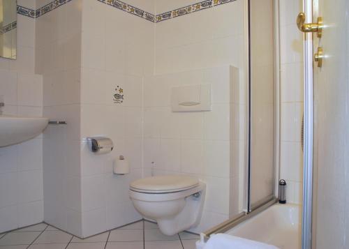 ein weißes Badezimmer mit Toilette und Dusche in der Unterkunft Ferienwohnungen in der Villa Regina Maris in Bansin