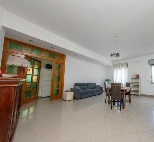 un soggiorno con un divano blu e un tavolo di Marisella holidays house a Pozzuoli