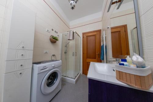 un bagno con lavatrice e lavandino di Marisella holidays house a Pozzuoli