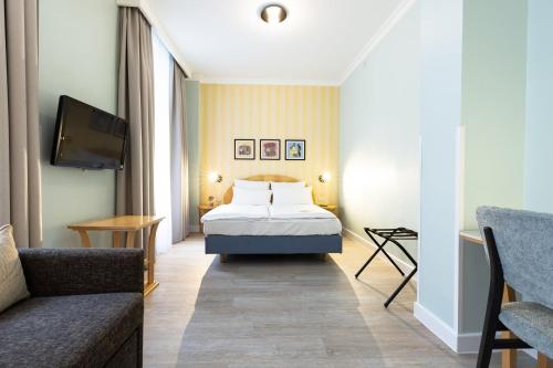 ein Hotelzimmer mit einem Bett und einer Couch in der Unterkunft Garner Hotel Berlin - Messe by IHG in Berlin