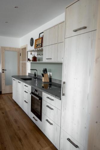 a kitchen with white cabinets and a black counter top at ReiWaSchHOF in Dobersberg