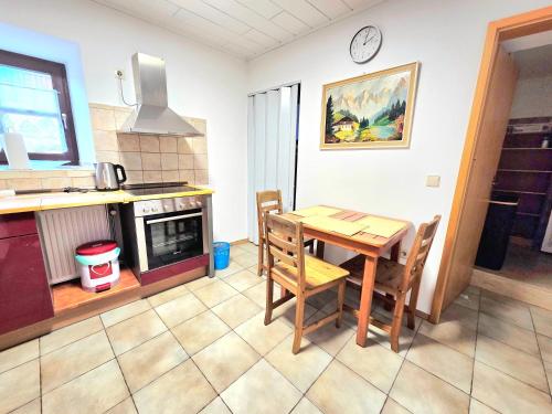 una cucina con un tavolo e sedie in una stanza di Ferienwohnung an der Altmühl - Apartment Hollerstein a Pappenheim