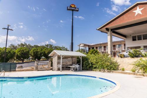a swimming pool with a gazebo next to a building at Boerne Inn and Suites in Boerne