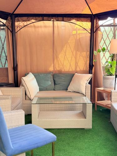 a couch in a gazebo with a table and a chair at Best Place Holiday Home IIII Free Parking in Ajman