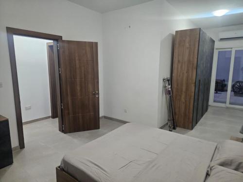 a bedroom with a bed and two wooden cabinets at Maisonette Gzira in Il-Gżira