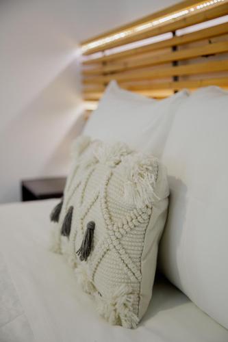 a white pillow sitting on top of a bed at IRIS Boutique Rooms in Korinthos