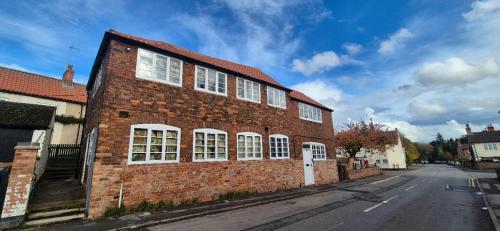 a brick building with white windows on a street at Spacious & Luxury 2BR Flat in Calverton in Calverton