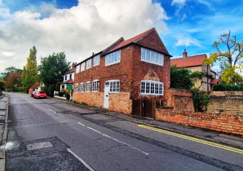 a brick building on the side of a street at Spacious & Luxury 2BR Flat in Calverton in Calverton