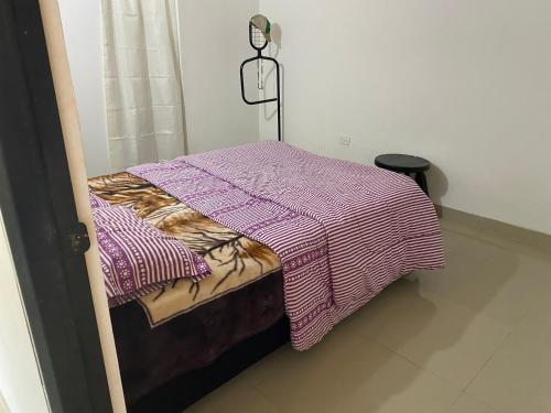 a bed with a blanket on top of it at El Guadualito in Pitalito