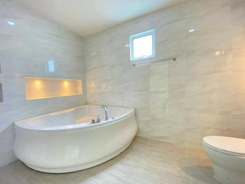 un bagno bianco con vasca e WC di IRIN Hill Pool Villa Huahin Pranburi a Ban Nong Ban Kao