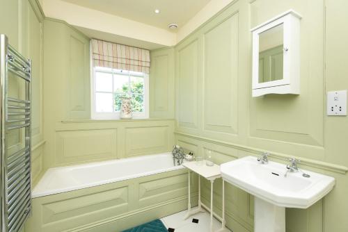 a bathroom with two sinks and a tub and a window at The Old Vicarage in Wadebridge