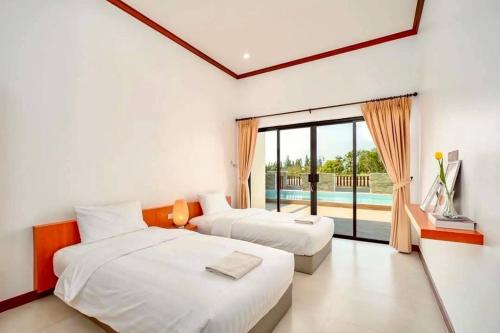 una camera da letto con due letti e una grande finestra di IRIN Hill Pool Villa Huahin Pranburi a Ban Nong Ban Kao