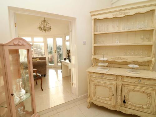 a room with a large cabinet with glasses on it at Ivy's End in Loughborough