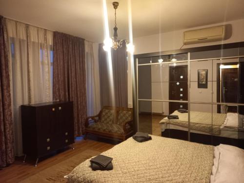 una camera con due letti, una sedia e uno specchio di Șoimului 27 No Smoking Apart a Craiova