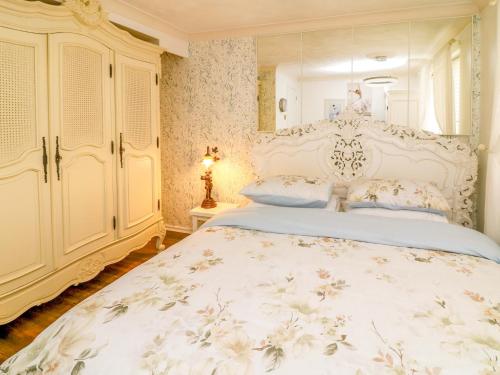 a bedroom with a large bed with a white bedspread at Ivy's End in Loughborough