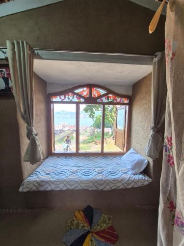 Kirti kewat Homestay في Maheshwar: سرير صغير في غرفة بها نافذة