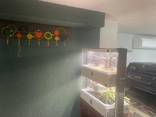 a room with a fish tank and some decorations on the wall at Aila apartment in Tokyo
