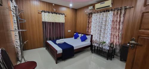 コーラムにあるNima Residencyの青い枕が付いたベッドのある寝室