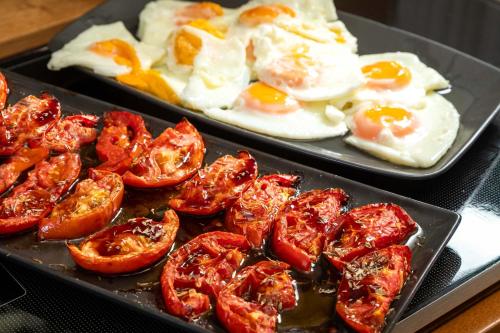 two plates of food with eggs and tomatoes at Bella Vista Beach Hotel in Benitses