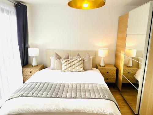 een slaapkamer met een groot bed en twee lampen bij Westferry Deluxe Apartment 3 in Londen