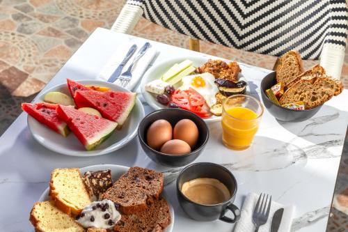 una mesa cubierta con platos de alimentos y huevos para el desayuno en Bella Vista Beach Hotel, en Benitses