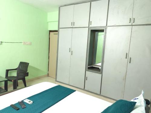 a room with a chair and a desk and cabinets at lighten homestay in Visakhapatnam