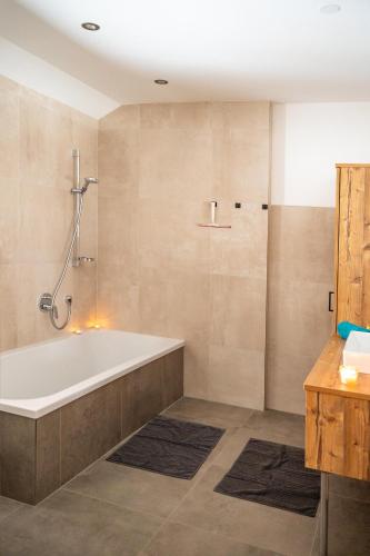 a bathroom with a bath tub and a shower at Mahdgut in Ramsau
