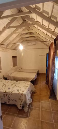 a bedroom with two beds and a ceiling with beams at El Cortijillo de la Marquesa in Villar