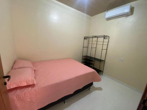 a small bedroom with a pink bed and a fan at Apto Flat in Belém