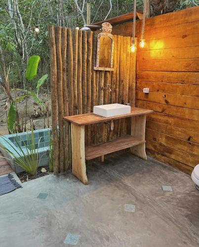 a bathroom with a sink on a wooden wall at Na Floresta Glamping in Pôrto de Pedras