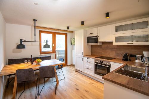 斯拉德明Urlpoldhof的配有白色橱柜和木桌的厨房