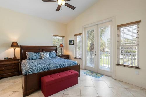 Schlafzimmer mit einem Bett und einer roten Ottomane in der Unterkunft Beach Breezes in Anna Maria Island