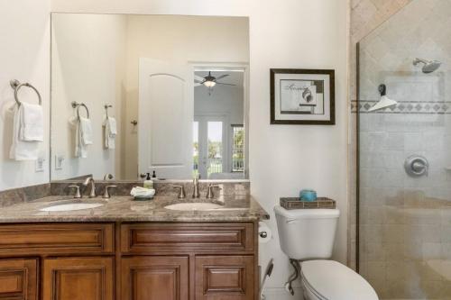 ein Badezimmer mit zwei Waschbecken, einer Toilette und einer Dusche in der Unterkunft Beach Breezes in Anna Maria Island